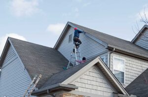 A roofer applies a reflective coating across a clean low-slope roof near repaired seams and drainage points.